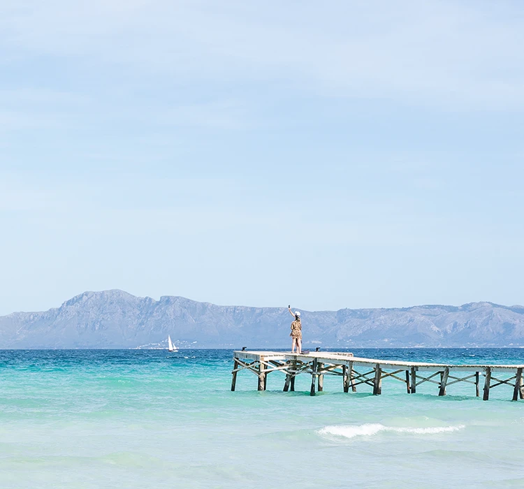 Advance your vacation promotion Woman taking photos of the beach from the pier at Alcudia Beach